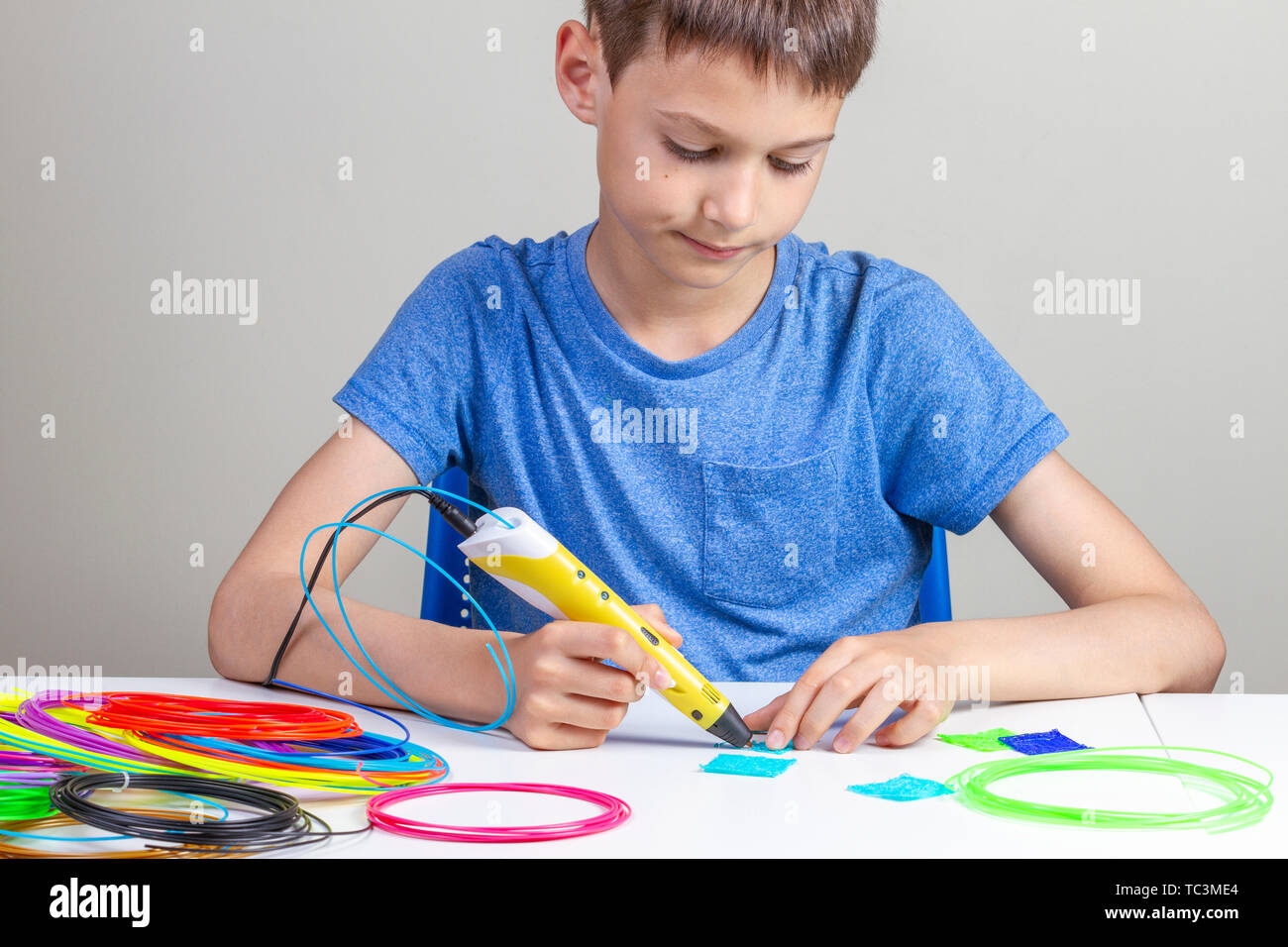 Boy creating with 3d printing pen new object Stock Photo - Alamy