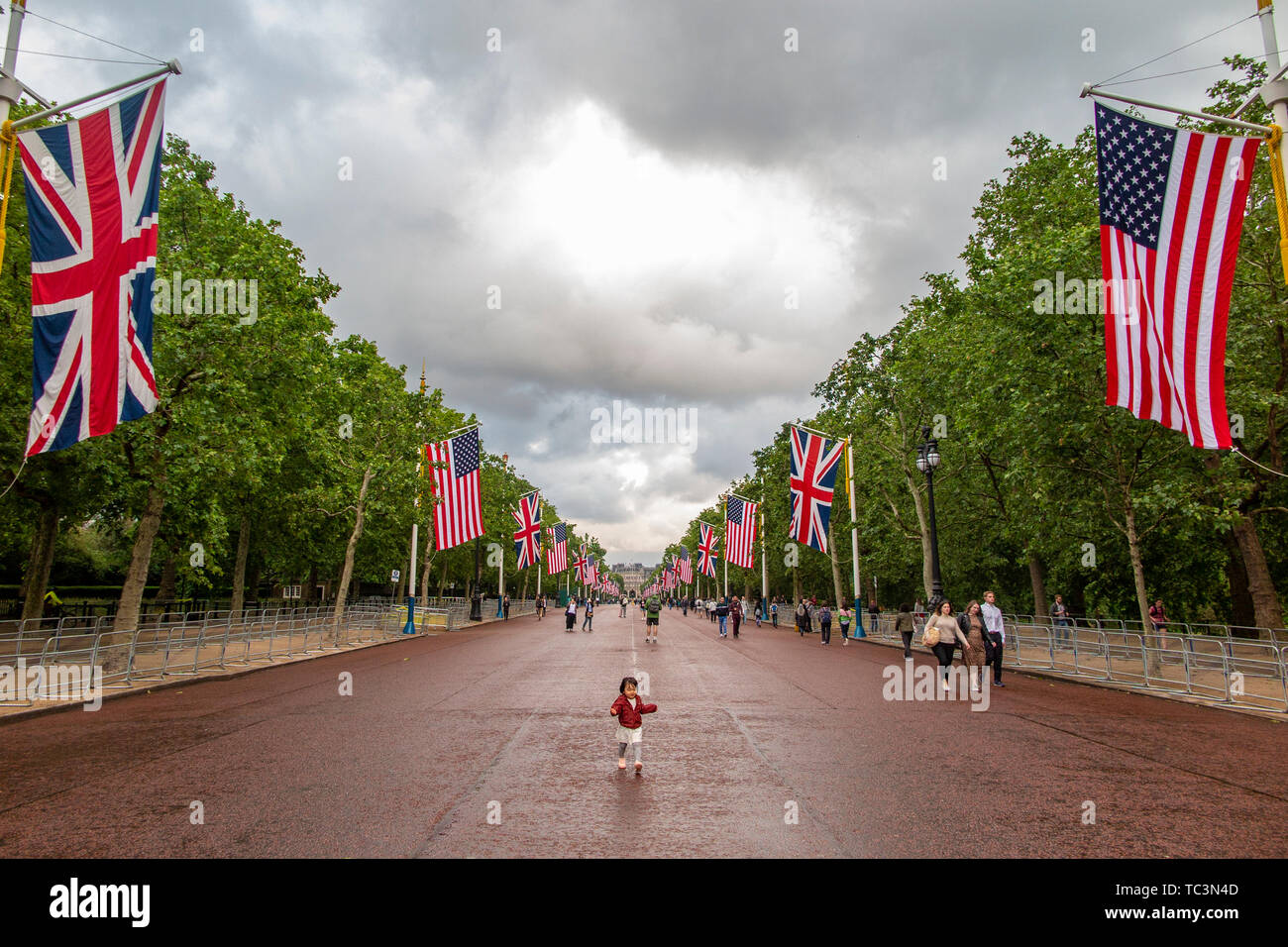 A sweet little girl dances on The Mall with Union and American flags and Buckingham Palace in the distance for Donald Trump's visit in June 2019 Stock Photo