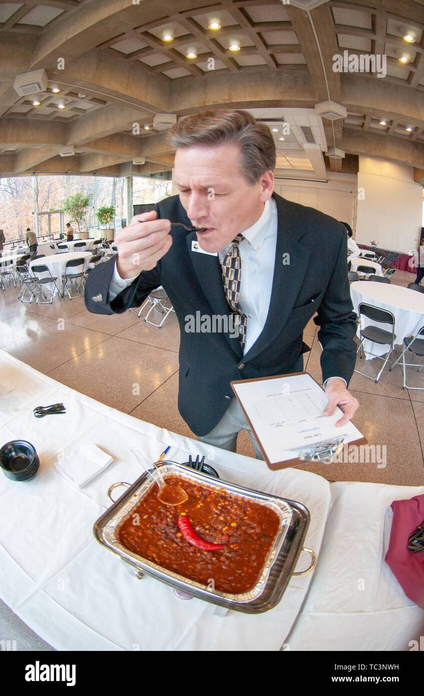 Close-up of a judge tasting chili while holding a clipboard in one hand, November 12, 2004. From the Homewood Photography Collection. () Stock Photo