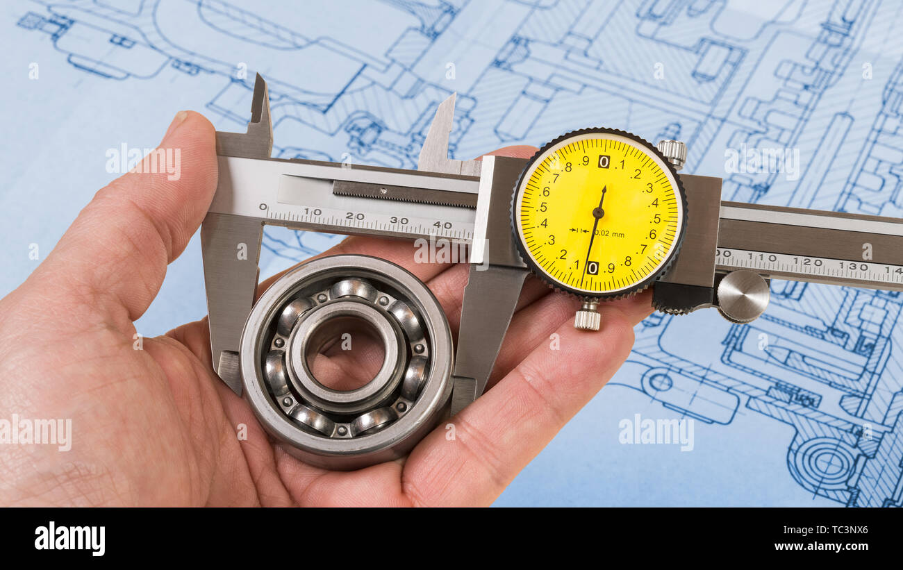 Ball bearing measurement. Vernier caliper in technician hand. Round steel part in jaws of