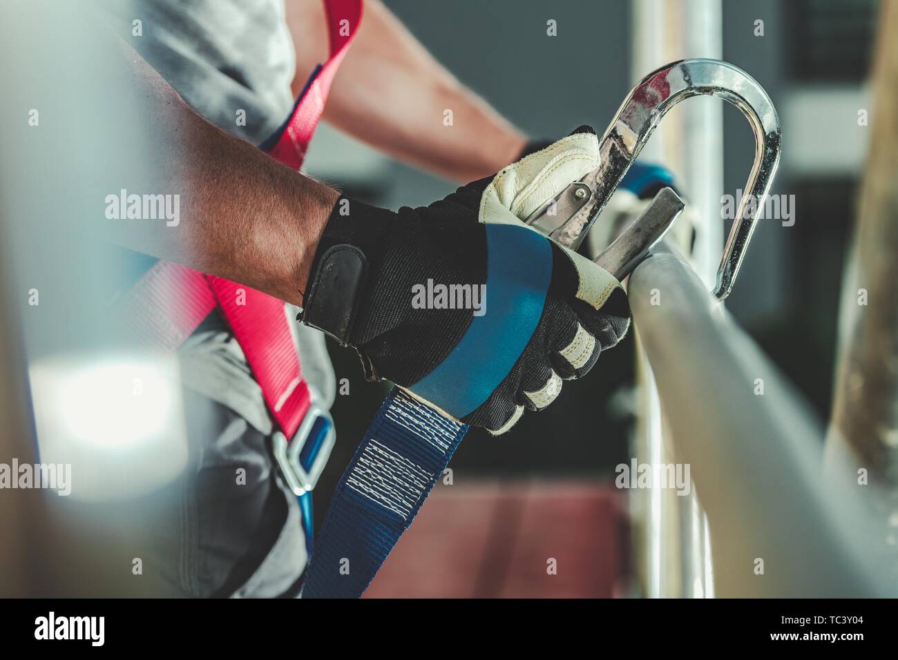 Safety Harness Hook Attaching to Scaffolding by Construction Worker