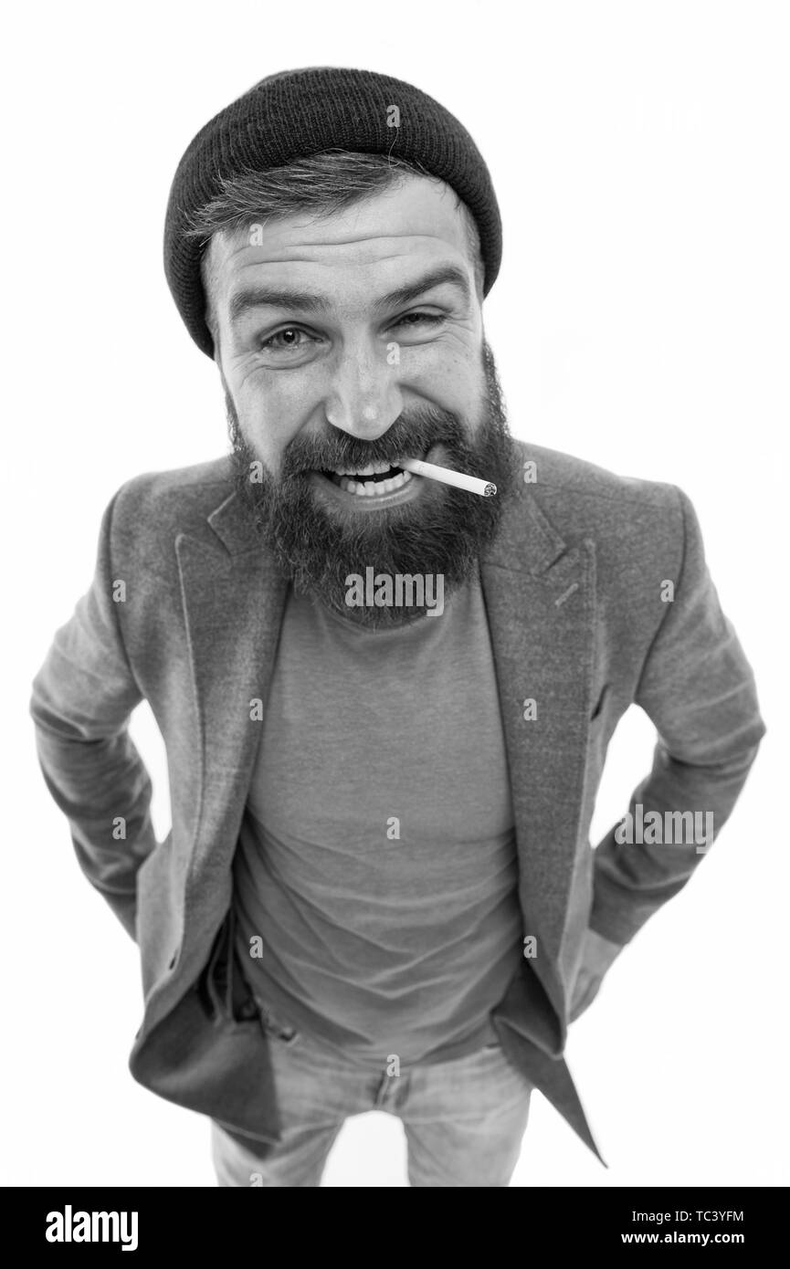 Hipster brutal bearded tobacco smoker. Brutality and masculinity. Brutal unshaven guy smoking white background close up. Man brutal bearded hipster smoking cigarette. Brutal habits and lifestyle. Stock Photo