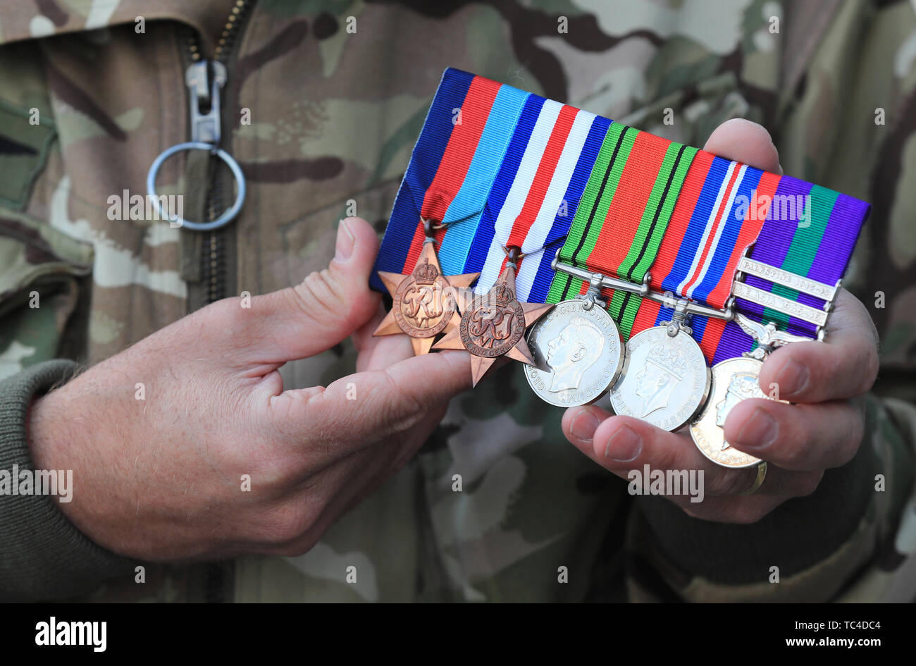 Colonel Andrew Jackson, Deputy Commander 16 Air Assault Brigade, holds the medals earned by his wife Kate's great-uncle Lieutenant Richard Price, who parachuted as part of the D-Day Invasion. Colonel Jackson is taking part in a commemorative parachute drop to mark the invasion 75 years ago. Stock Photo