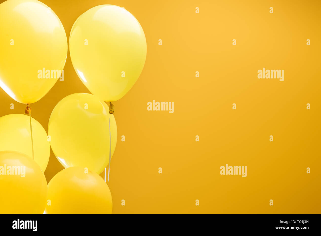 festive minimalistic decorative balloons on yellow background with copy ...