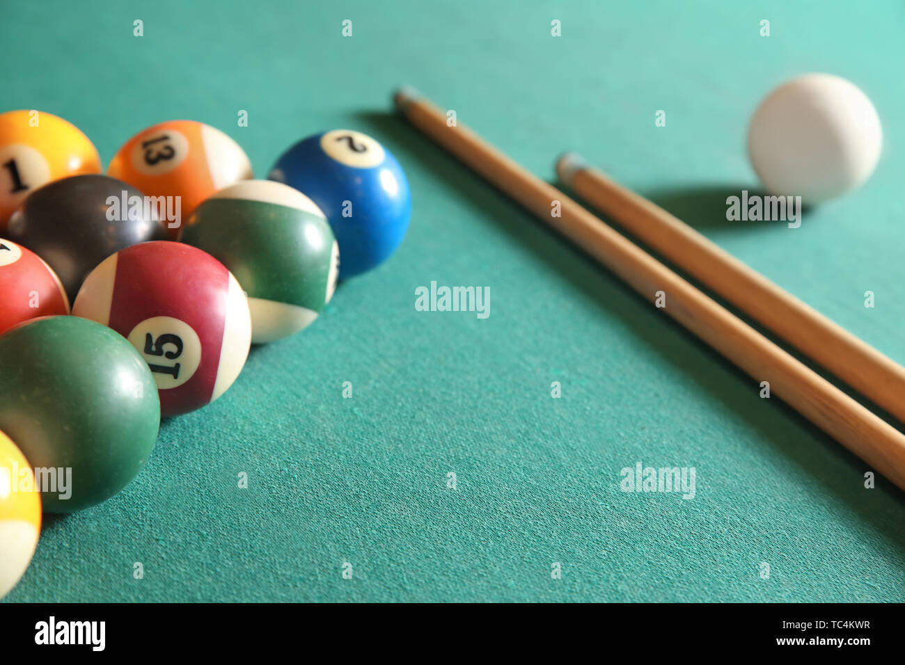 Billiard balls with cues on table Stock Photo