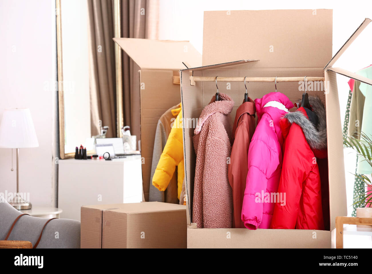 Wardrobe boxes with clothes in room Stock Photo Alamy