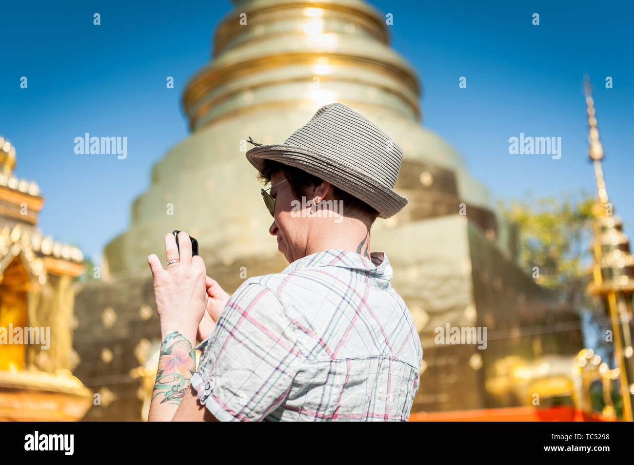 A tourist takes a photo of the ornate temple design at the famous Wat Phra Sing Thai Temple Chiang Mai, Thailand. Stock Photo