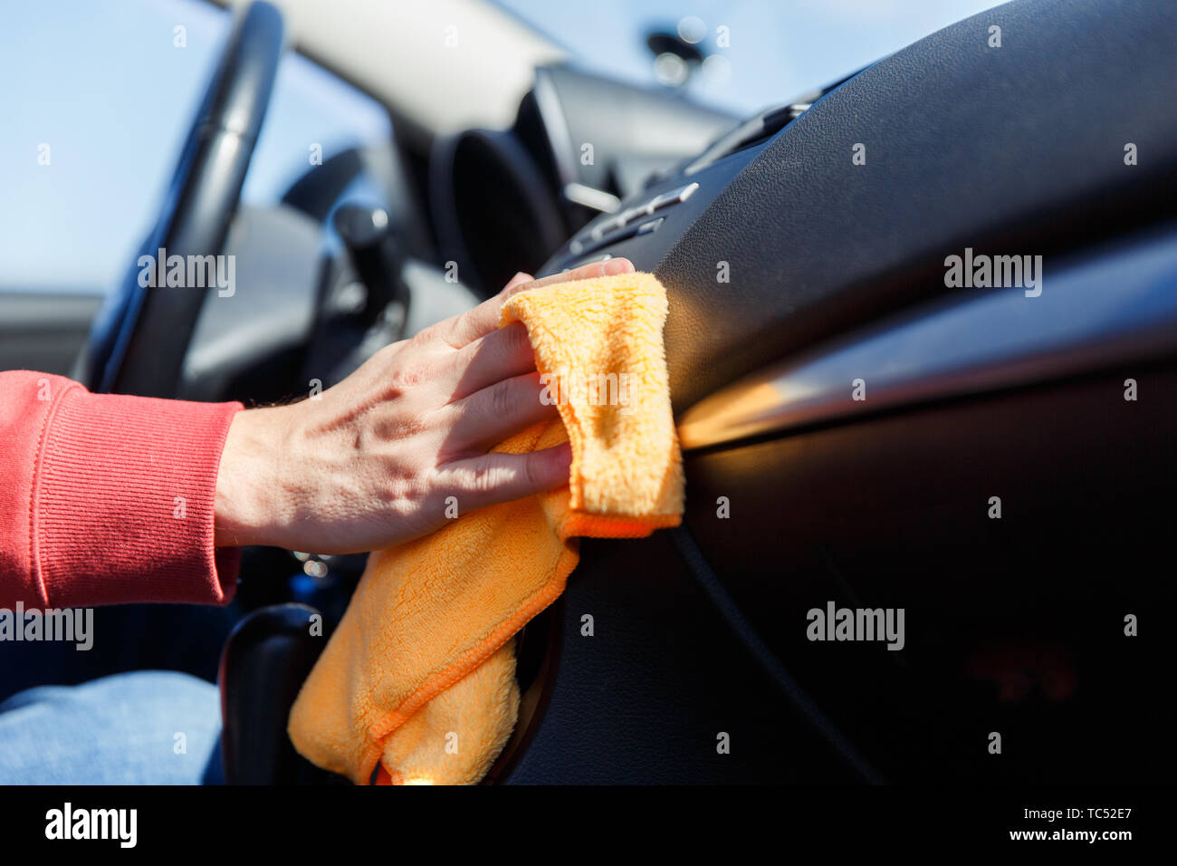 Picture of man's hand with orange rag washing car interior Stock Photo ...