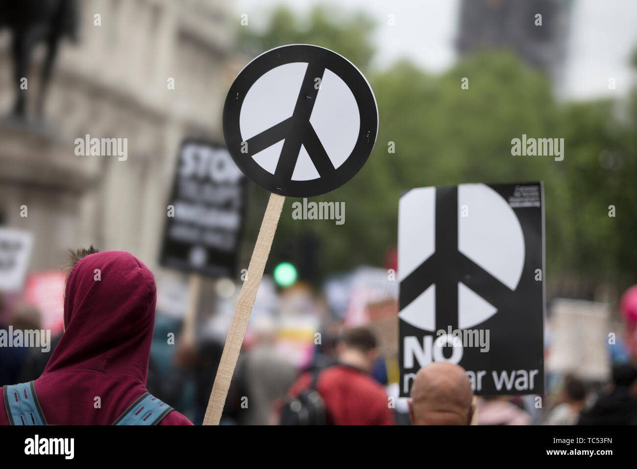 A person holds a peace sign banner at a protest Stock Photo