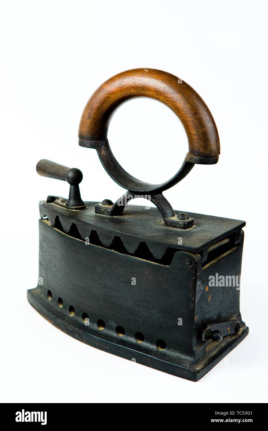 Vintage ironing tool, traditional steel coal iron with wooden handle