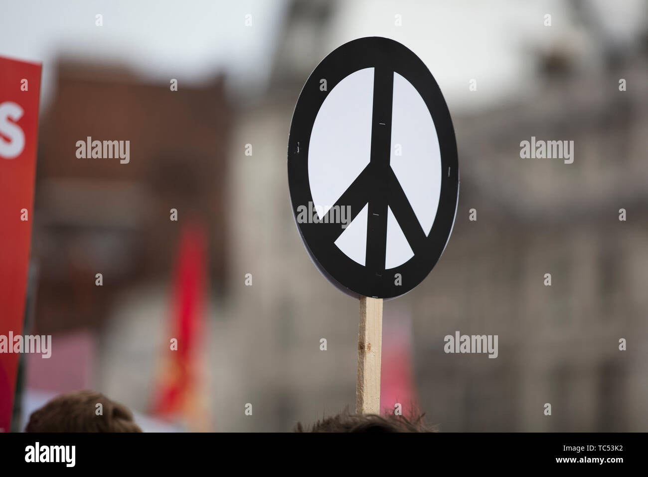 A person holds a peace sign banner at a protest Stock Photo