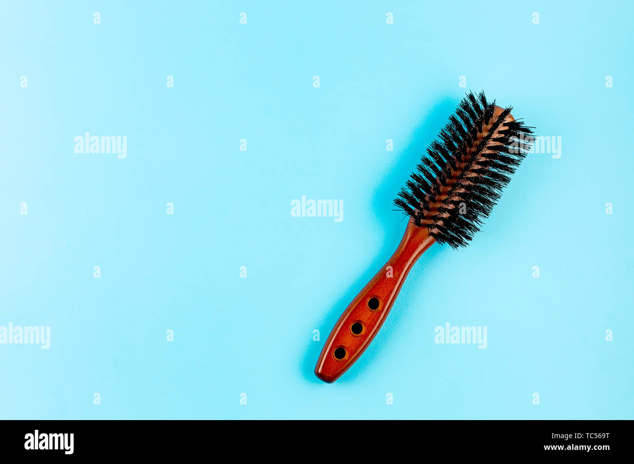 Wooden Hairbrush With Natural Boar Bristles On Blue Background
