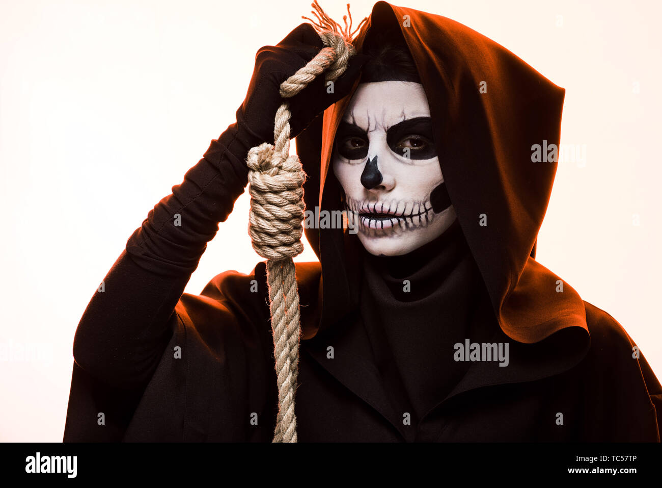 woman in death costume holding hanging noose isolated on white Stock Photo