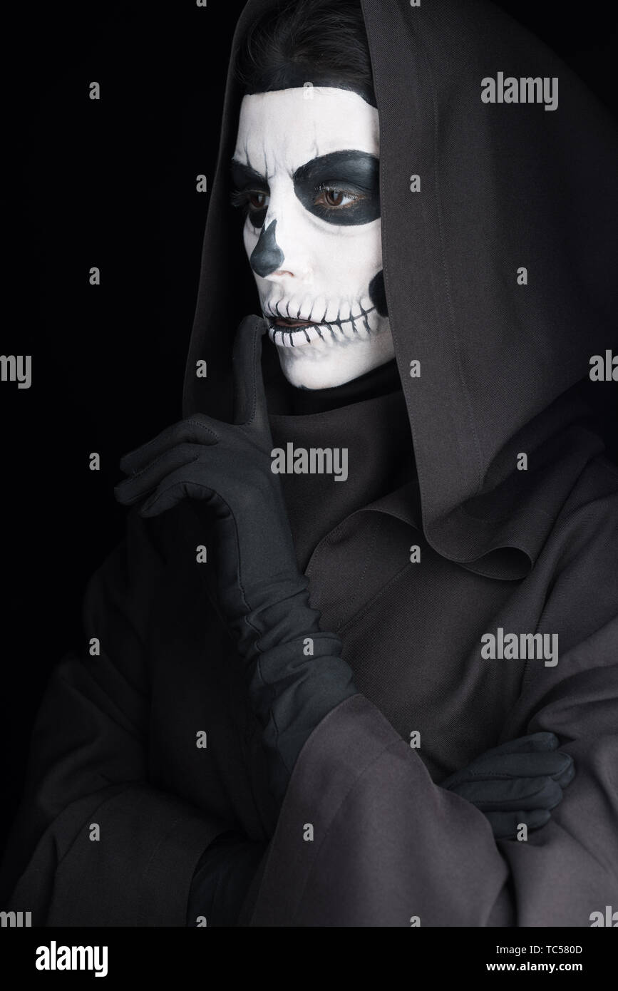 woman with skull makeup showing hush sign isolated on black Stock Photo