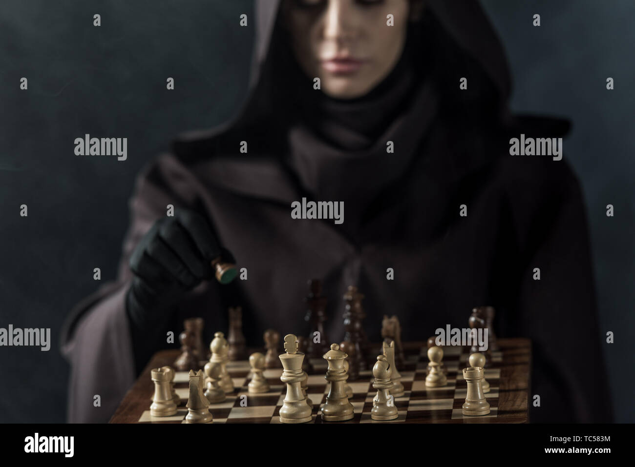 cropped view of woman in death costume playing chess on black Stock Photo -  Alamy