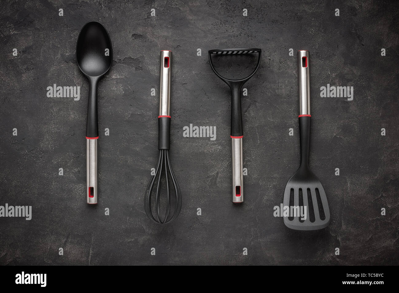 Modern Black Plastic Kitchen Utensils on Dark Background Stock Photo