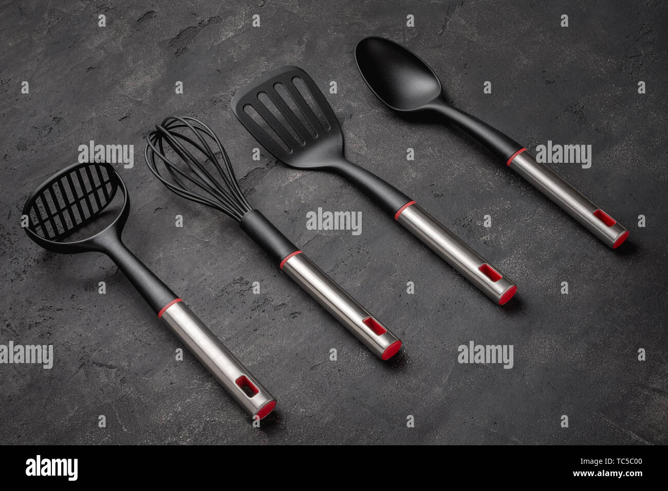 Modern Black Plastic Kitchen Utensils on Dark Background Stock Photo