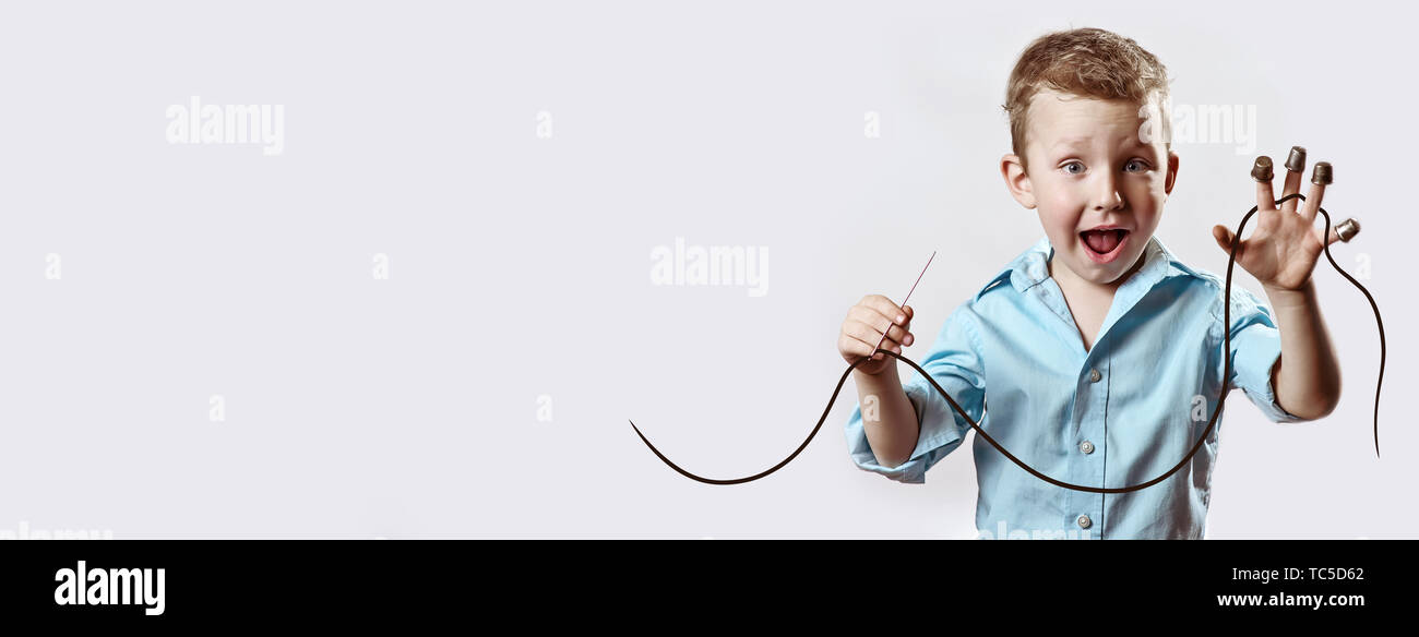 boy with a needle and thread in a blue shirt on a light background ...