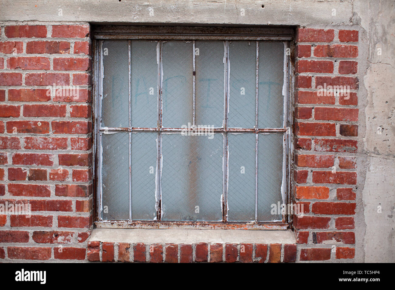 Window with the word 'Rapist' faintly visible written on the glass. Stock Photo