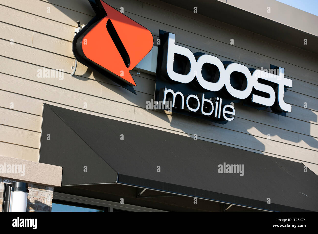 A logo sign outside of a Boost Mobile retail store location in