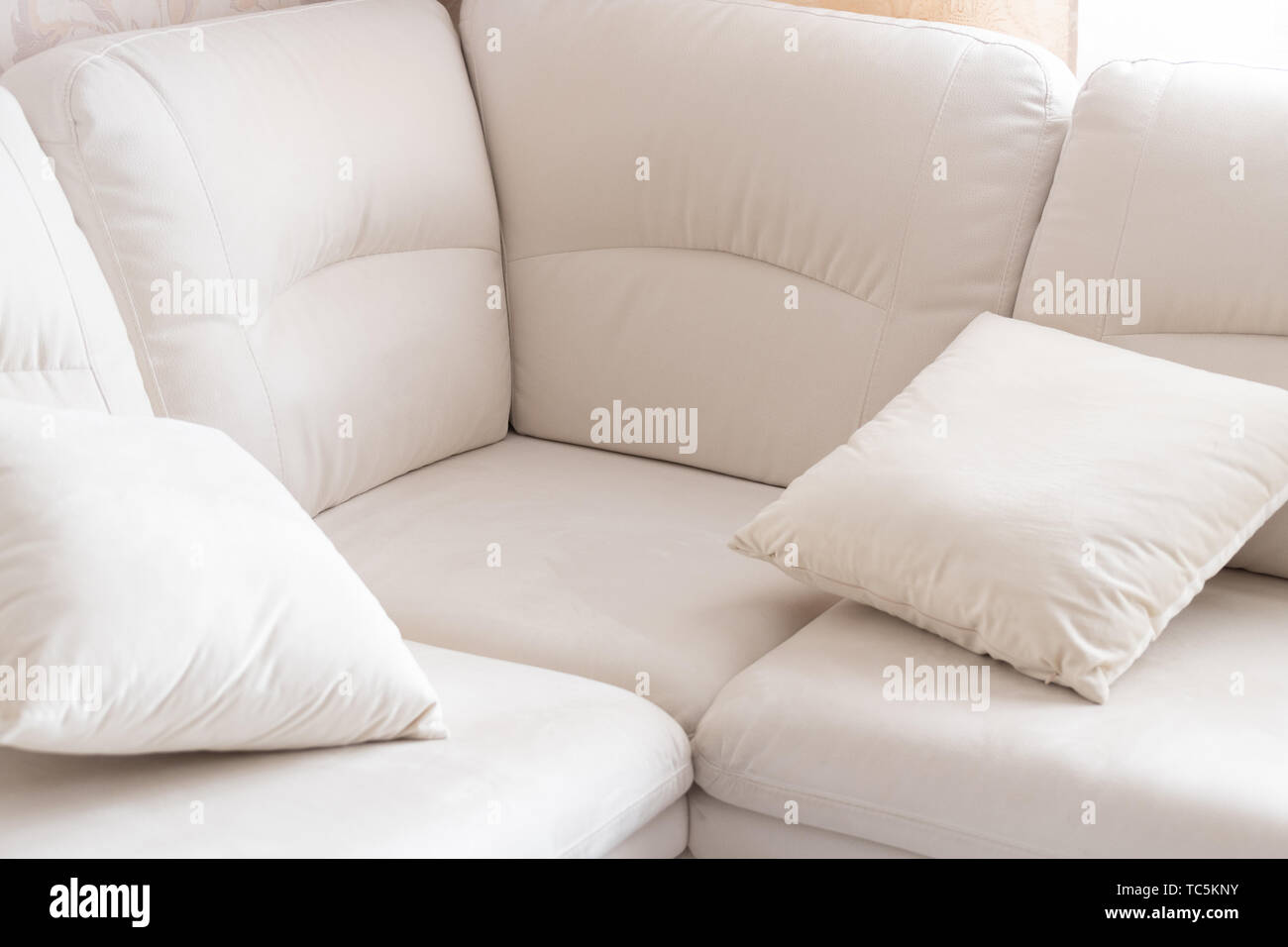 Empty white corner sofa with pillows Stock Photo