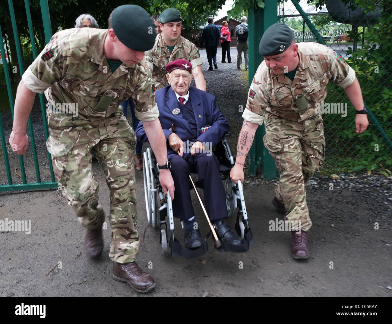 British army soldiers help Parachute Regiment (3 Para) veteran John Sleep, 98, from Windsor, who landed on Sword beach, during commemorations for the 75th anniversary of the D-Day landings. Stock Photo