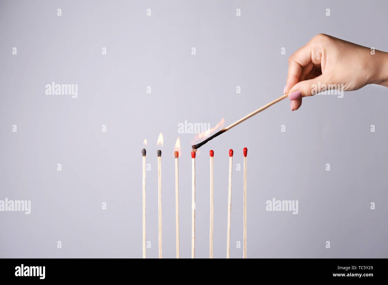 Female hand lighting matches on grey background Stock Photo Alamy