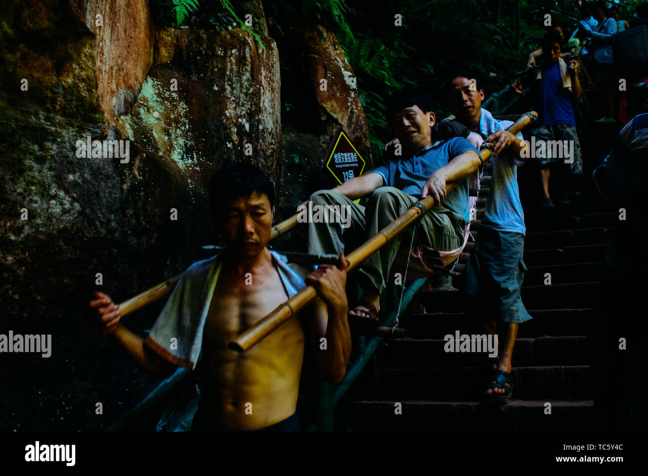 The sliding rod is a traditional means of transportation unique to the mountainous areas of southwest China. Bind into a stretcher with two sturdy long bamboo poles, a recliner made of bamboo slices or a sitting pocket made of ropes, and a hanging pedal. Stock Photo