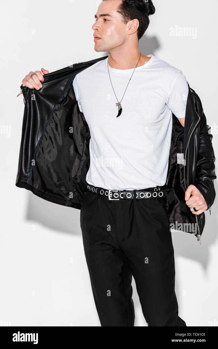 stylish man taking off leather jacket while standing on white Stock Photo