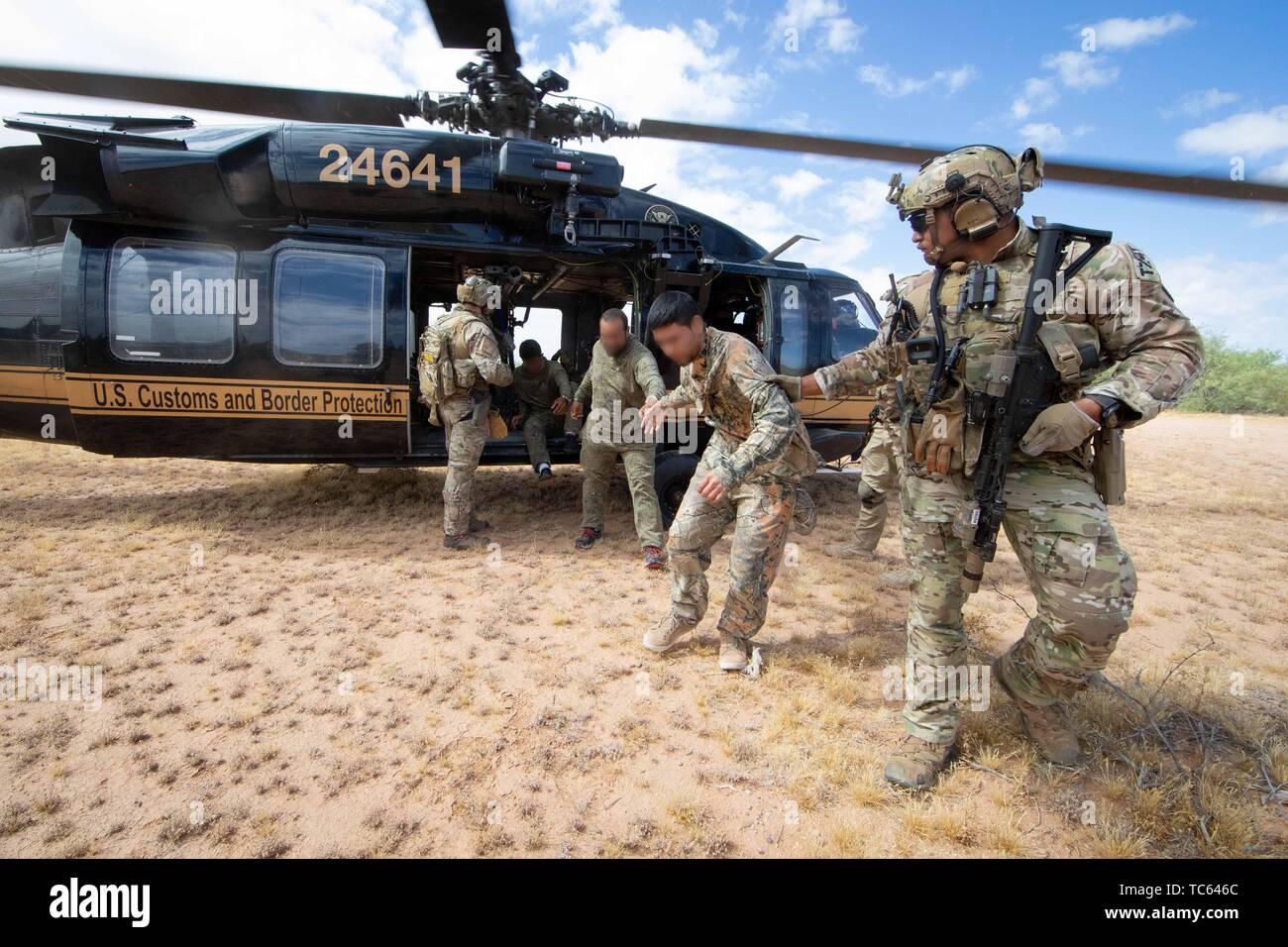 U.S. Border Patrol patrolling in a Blackhawk helicopter detected a group of illegal migrants after they crossed from Mexico on the Tohono Oʼodham Indian Reservation May 22, 2019 near Pisinemo, Arizona. The faces are obscured by the Border Patrol to protect their identity. Stock Photo