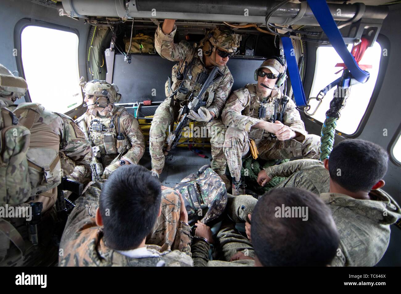 U.S. Border Patrol onboard a Blackhawk helicopter transport a group of illegal migrants after they crossed from Mexico on the Tohono Oʼodham Indian Reservation May 22, 2019 near Pisinemo, Arizona. The faces are obscured by the Border Patrol to protect their identity. Stock Photo