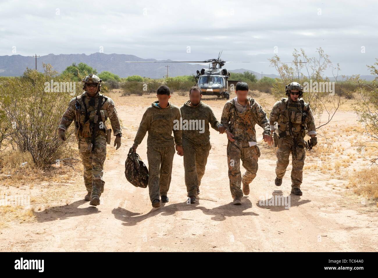 U.S. Border Patrol patrolling in a Blackhawk helicopter detected a group of illegal migrants after they crossed from Mexico on the Tohono Oʼodham Indian Reservation May 22, 2019 near Pisinemo, Arizona. The faces are obscured by the Border Patrol to protect their identity. Stock Photo