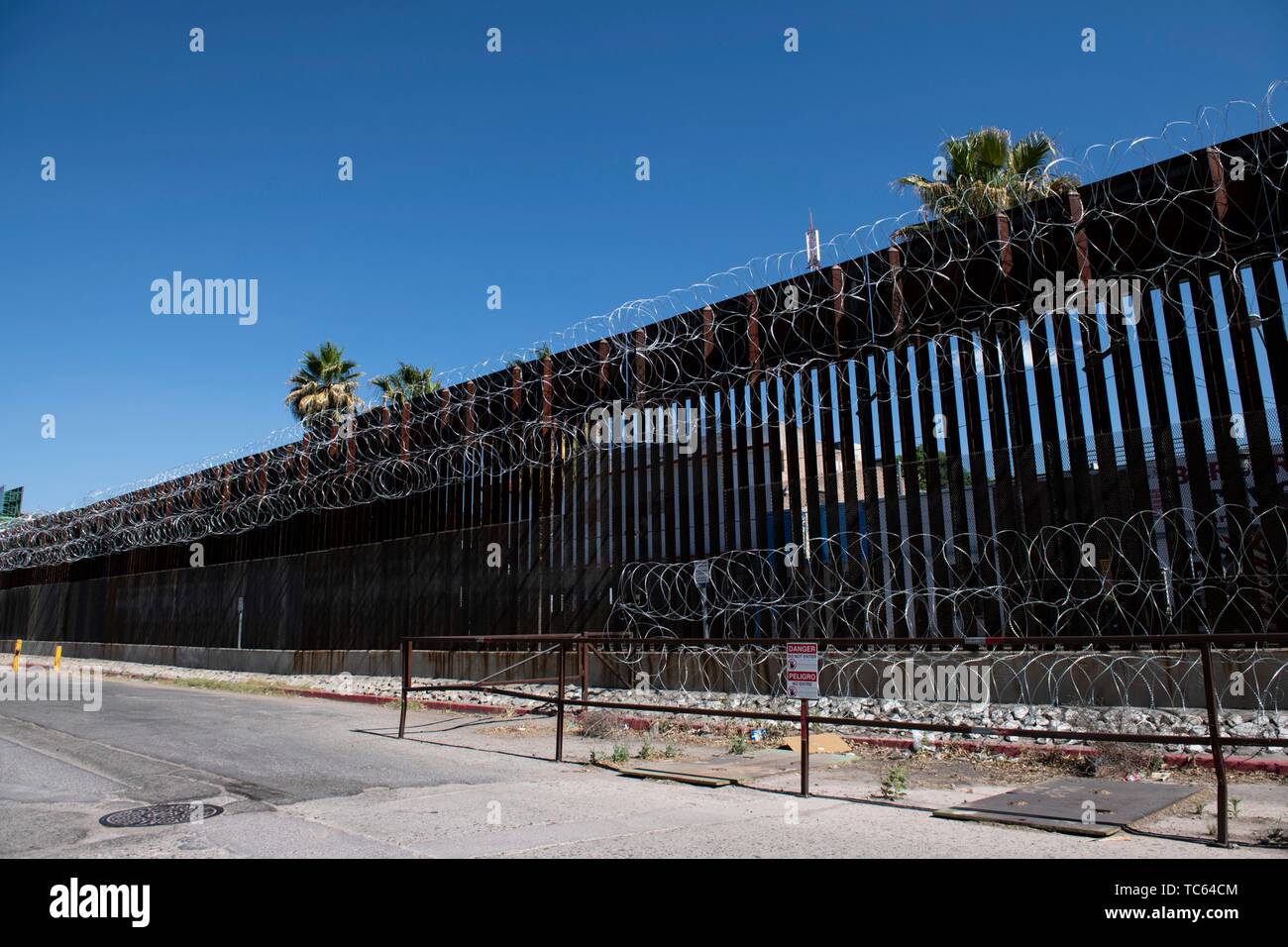 Razor wire covers the old metal border fence separating Mexico from the United States at the border crossing point May 29, 2019 at Nogales, Arizona. Stock Photo