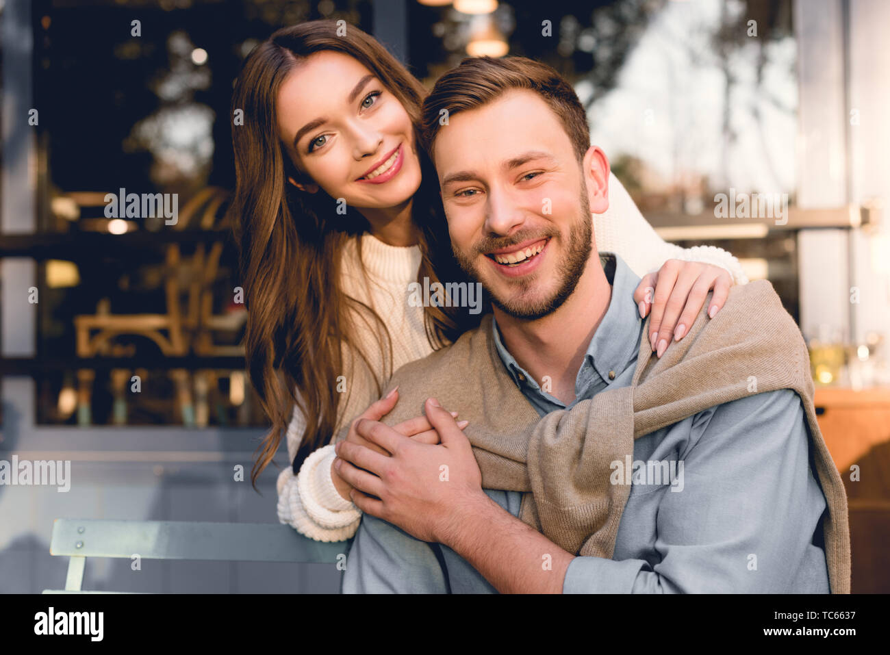 happy girl hugging handsome boyfriend and looking at camera Stock Photo ...