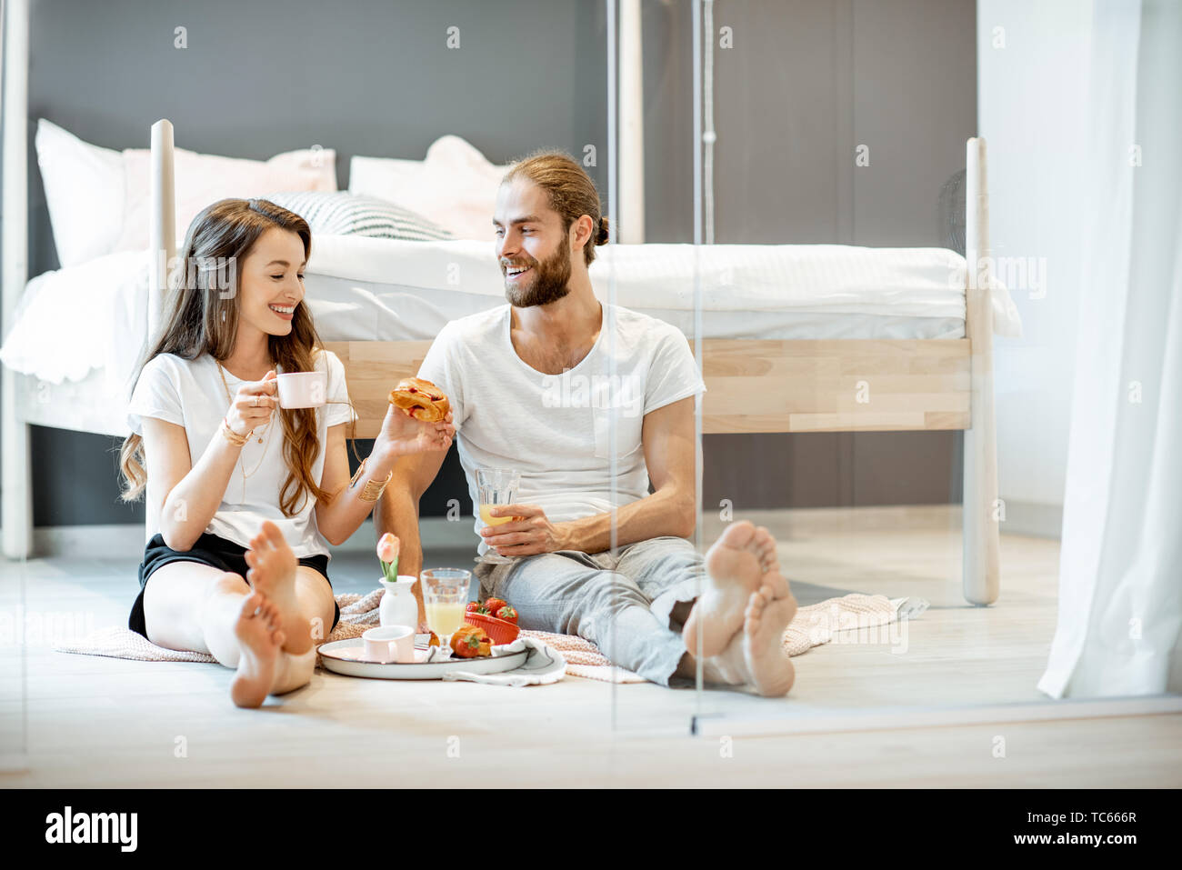 Young And Cheerful Couple Having A Breakfast Sitting