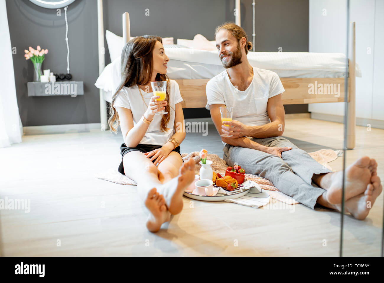 Young And Cheerful Couple Having A Breakfast Sitting