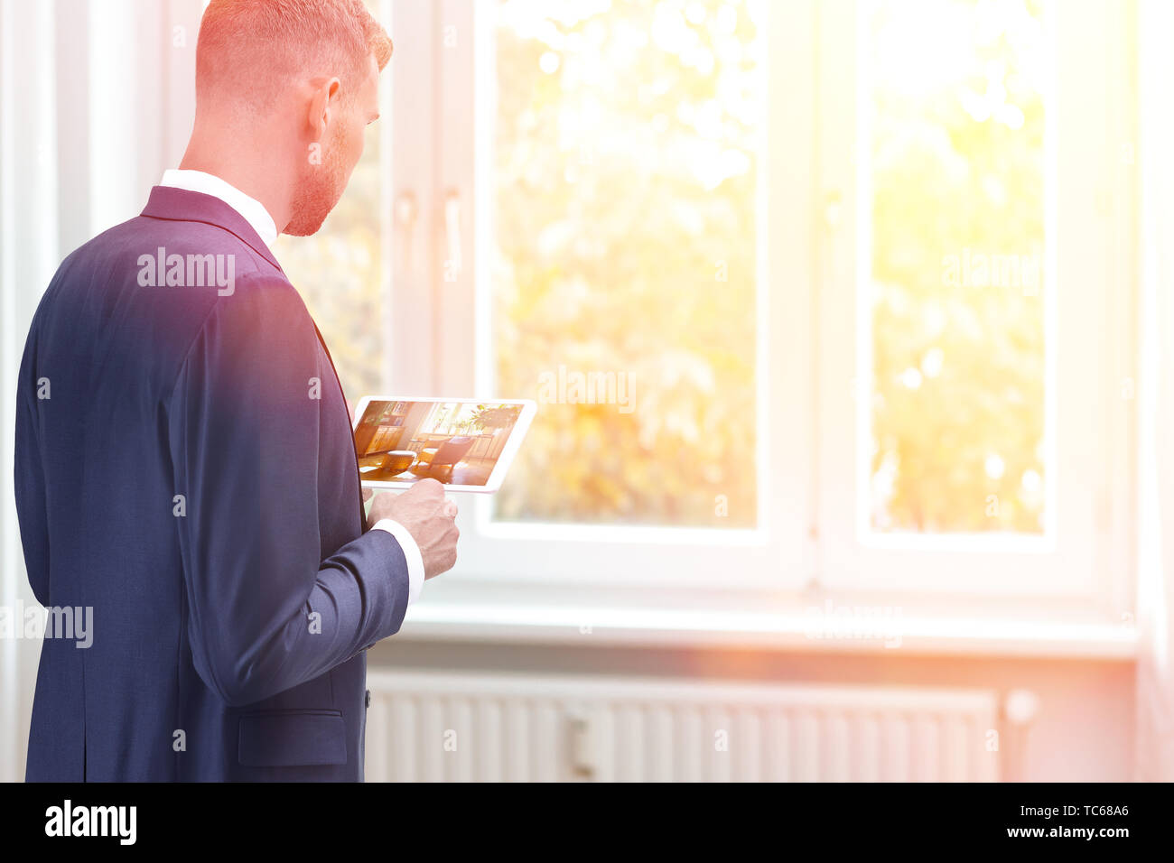 Home staging concept - home stager with a preview image of the redecorated room on a tablet computer. Stock Photo