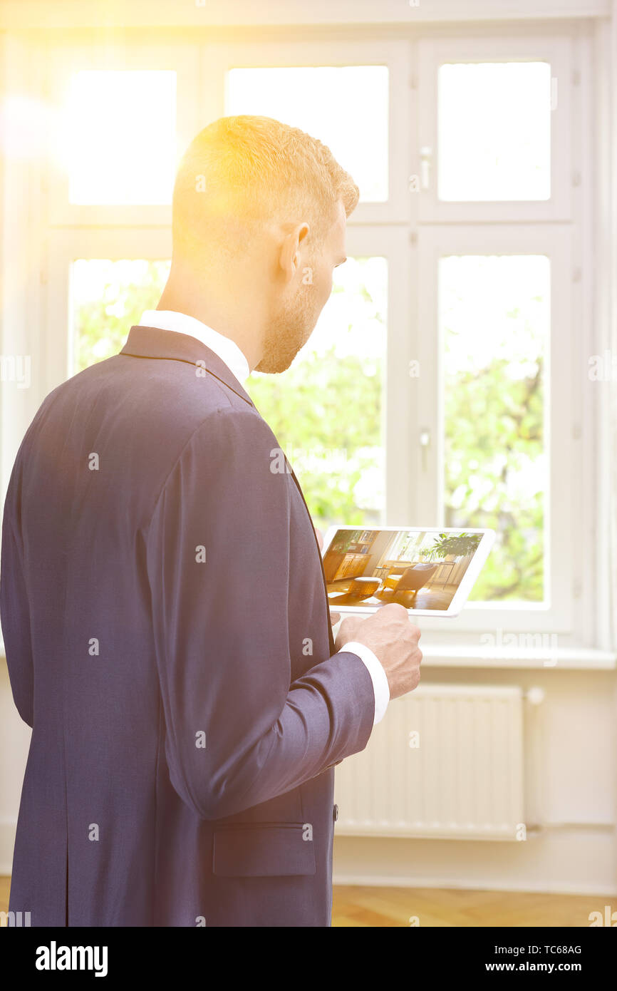 Home staging concept - home stager with a preview image of the new furniture and decoration on a tablet computer. Stock Photo