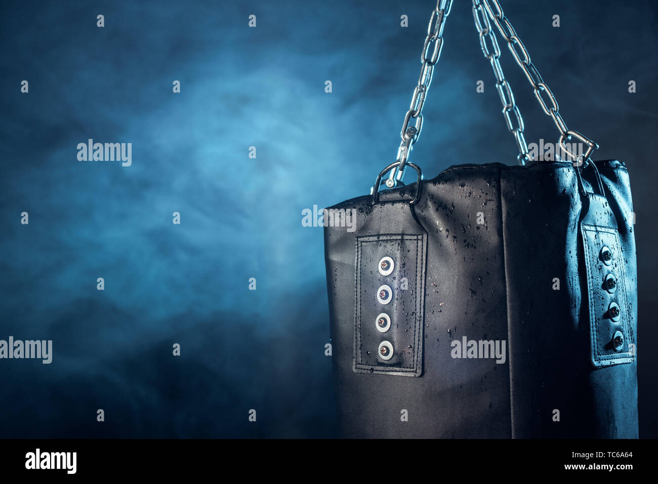 Leather punching bag hanging on steel chains on dark Stock Photo Alamy