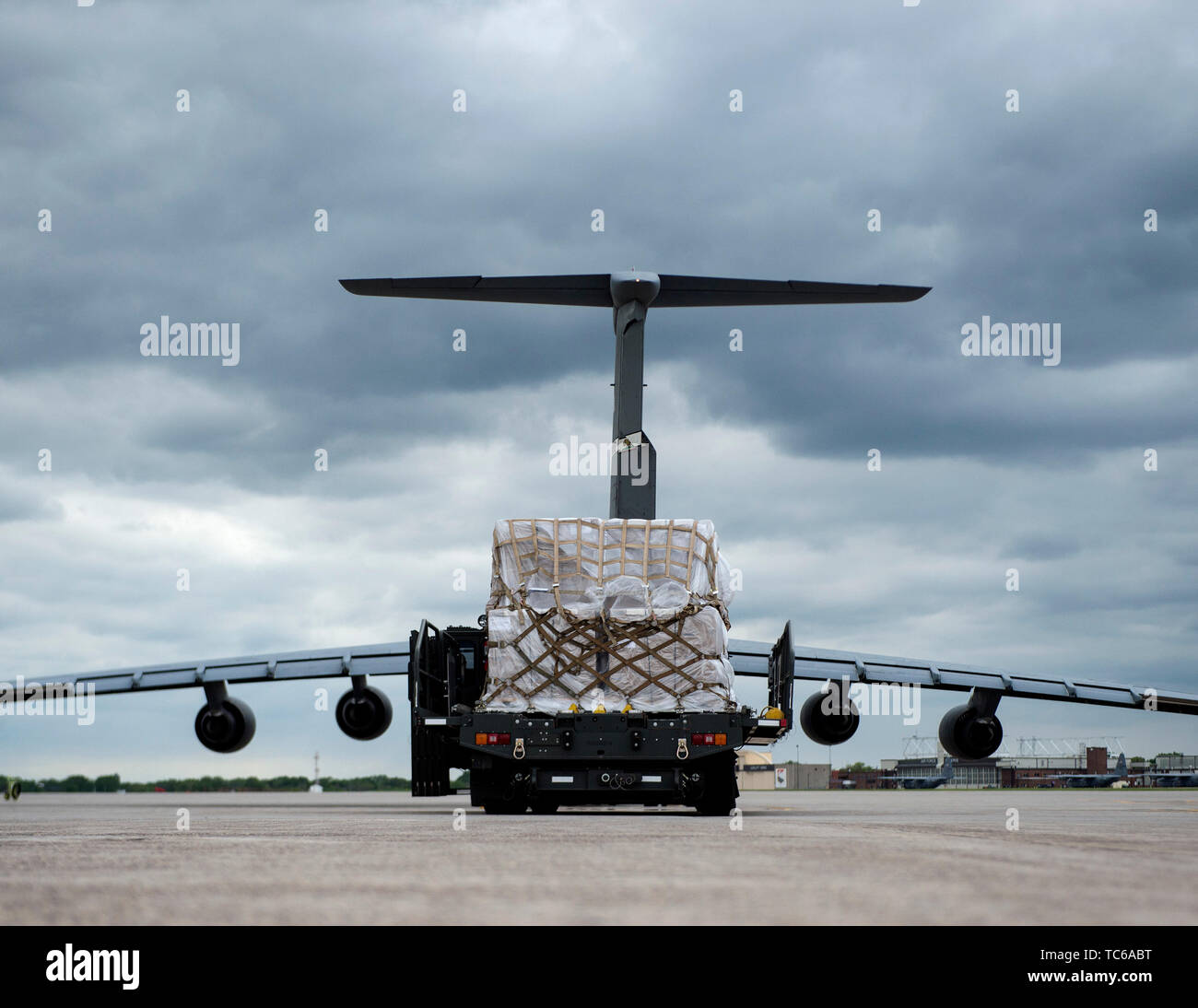 A 60K Loader from the 133rd Small Air Terminal waits to off load the cargo onto a C-5 Galaxy in St. Paul, Minn., May 22, 2019. The Airmen are taking part in the Denton Program which is a Department of Defense transportation program that moves humanitarian cargo, donated by the U.S. based Non-Governmental Organizations to developing nations to ease human suffering.  (U.S. Air National Guard photo by Amy M. Lovgren) Stock Photo