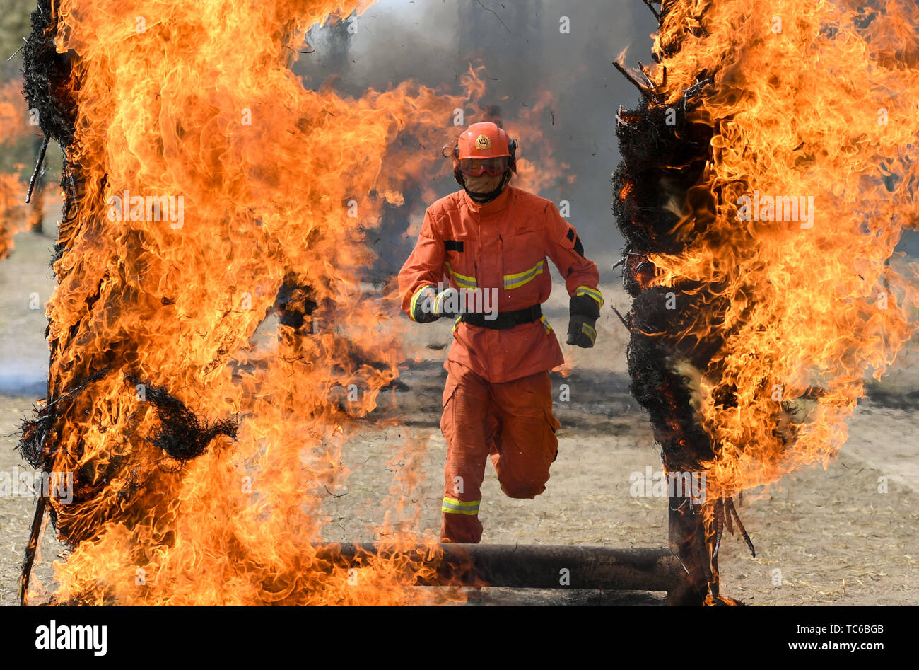 Hohhot, China's Inner Mongolia Autonomous Region. 5th June, 2019. A newly-recruited fireman runs through a fire wall during a training in Hohhot, north China's Inner Mongolia Autonomous Region, June 5, 2019. Over 1,100 socially-recruited firemen are receiving a six-month training in Hohhot. Credit: Peng Yuan/Xinhua/Alamy Live News Stock Photo