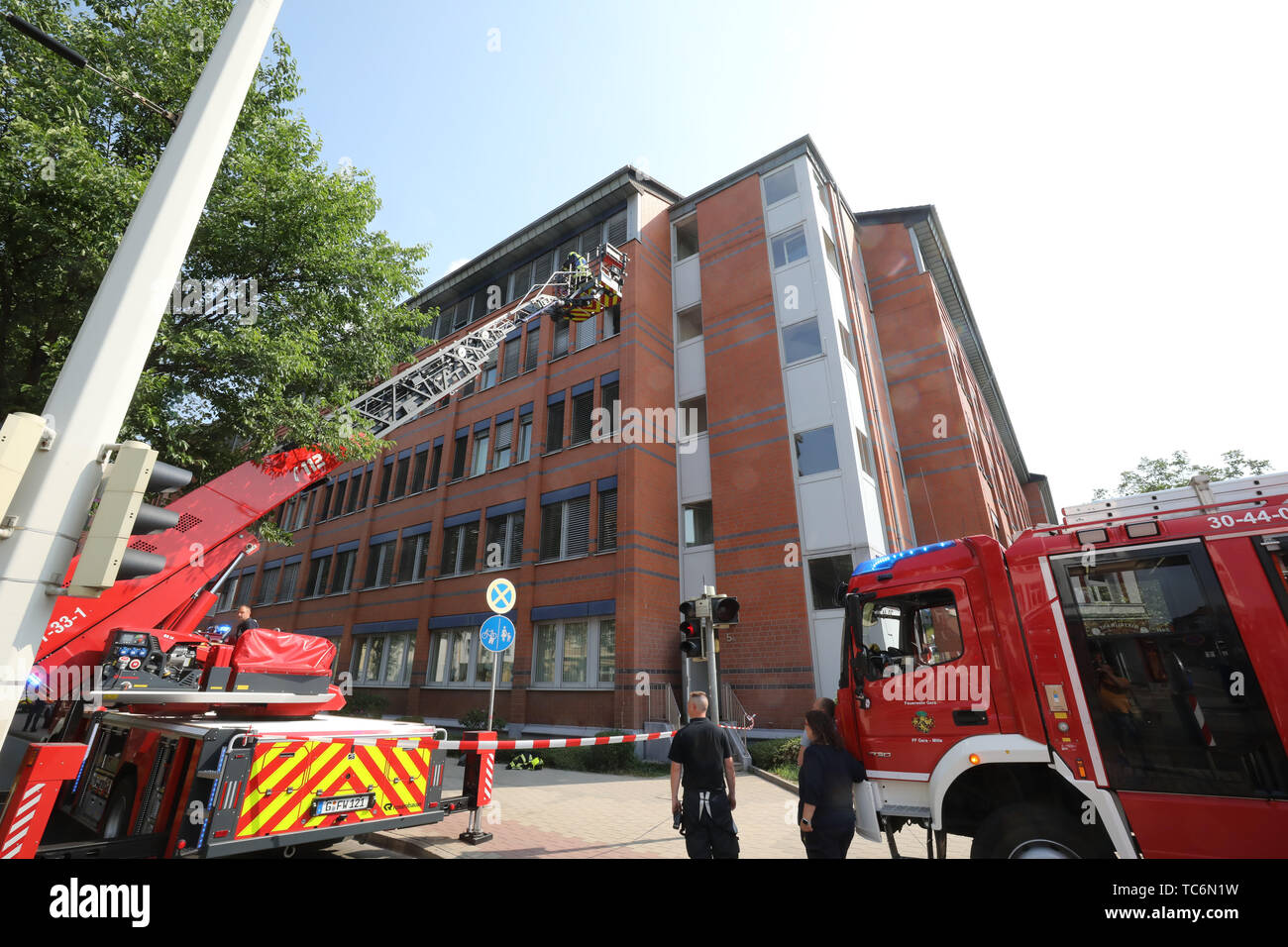 Gera, Germany. 06th June, 2019. Firefighters are standing in front of the building of the Bundesversicherungsanstalt für Angestellte (BfA). A fire had broken out on the fourth floor of a part of the building in the morning and was extinguished by the fire brigade. This floor is used by a company not belonging to the BfA. About 600 people were evacuated. Police are investigating the cause of the fire. Credit: Bodo Schackow/dpa-Zentralbild/dpa/Alamy Live News Stock Photo