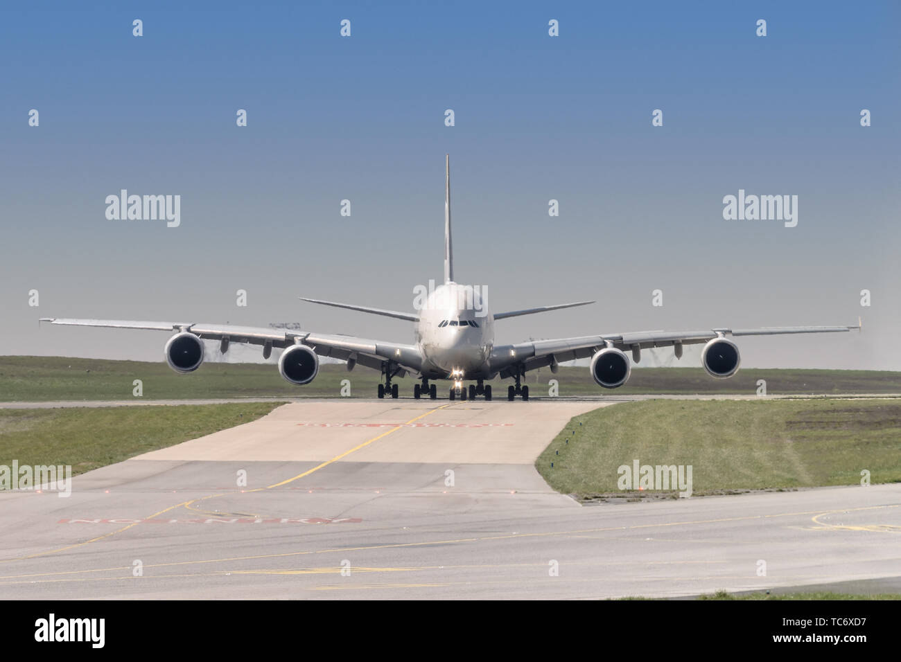 front view of a four engine big jet plane waiting on a taxiway for taking off permission. Stock Photo