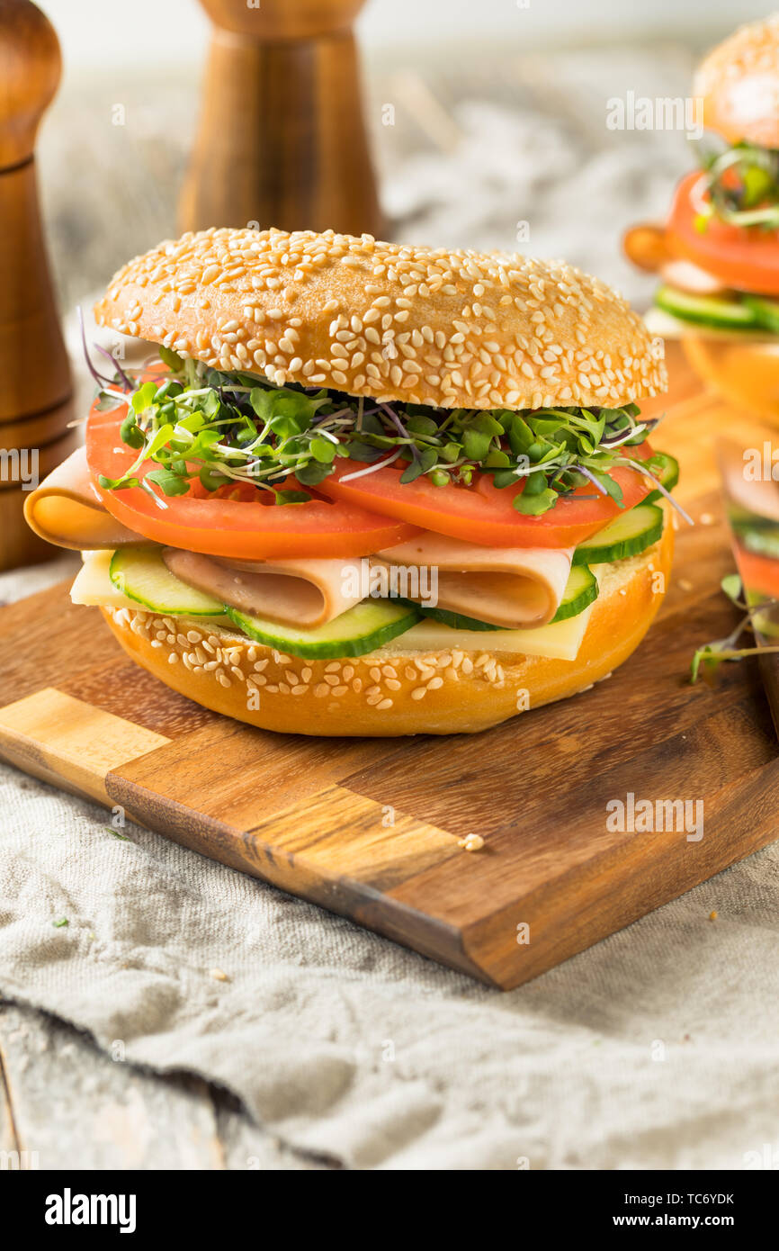 Homemade Bagel Turkey Sandwich with Tomato and Cucumber Stock Photo