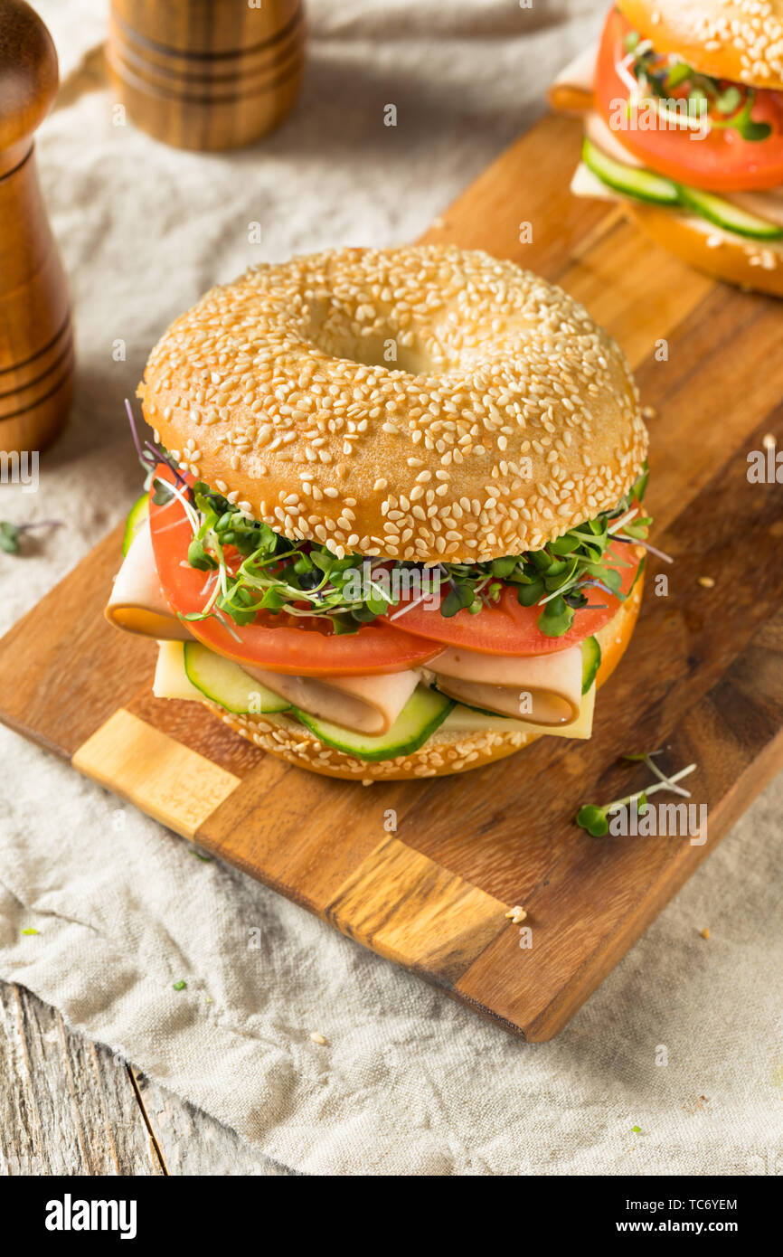 Homemade Bagel Turkey Sandwich with Tomato and Cucumber Stock Photo