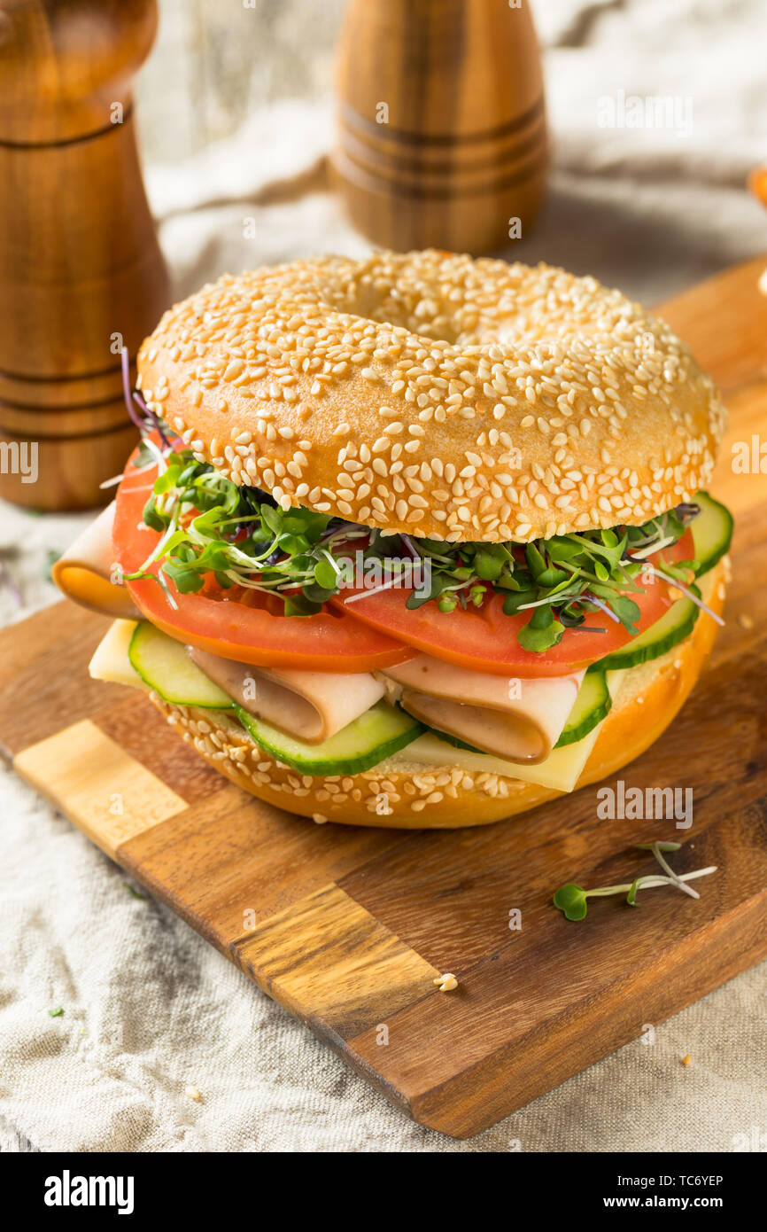 Homemade Bagel Turkey Sandwich with Tomato and Cucumber Stock Photo