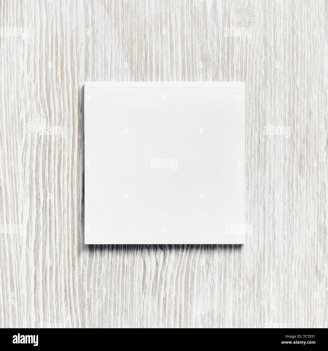 Blank square notepad on light wood table background. Responsive design ...