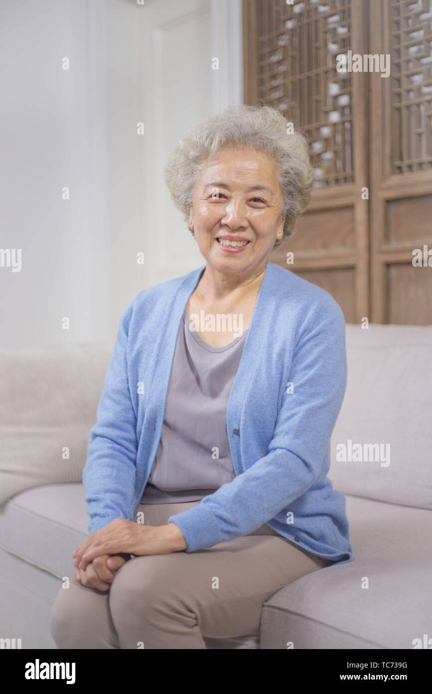 Old woman sitting on sofa hi-res stock photography and images - Alamy