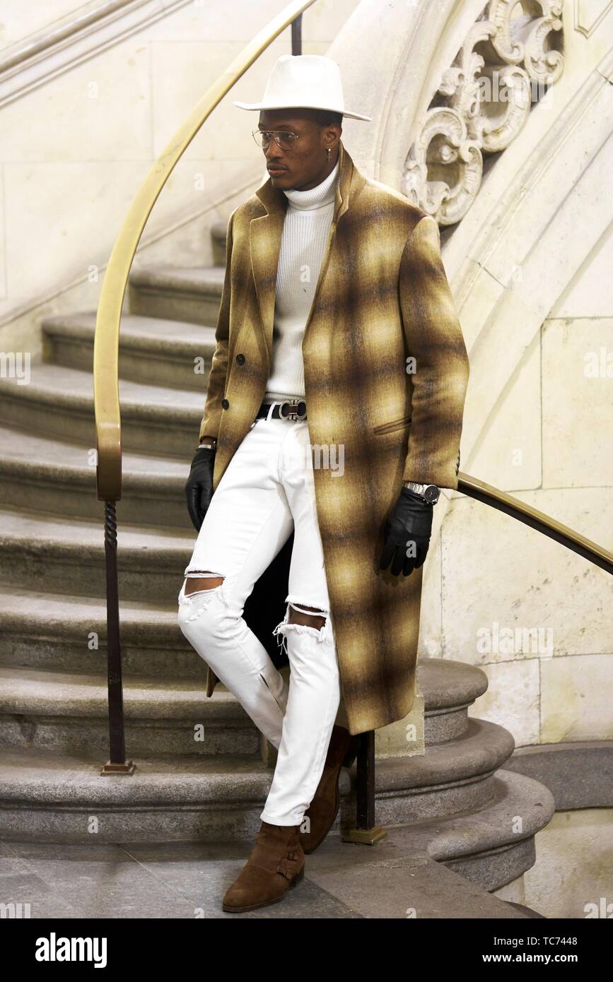 stylish wealthy man wearing expensive clothes, standing on stairs, in