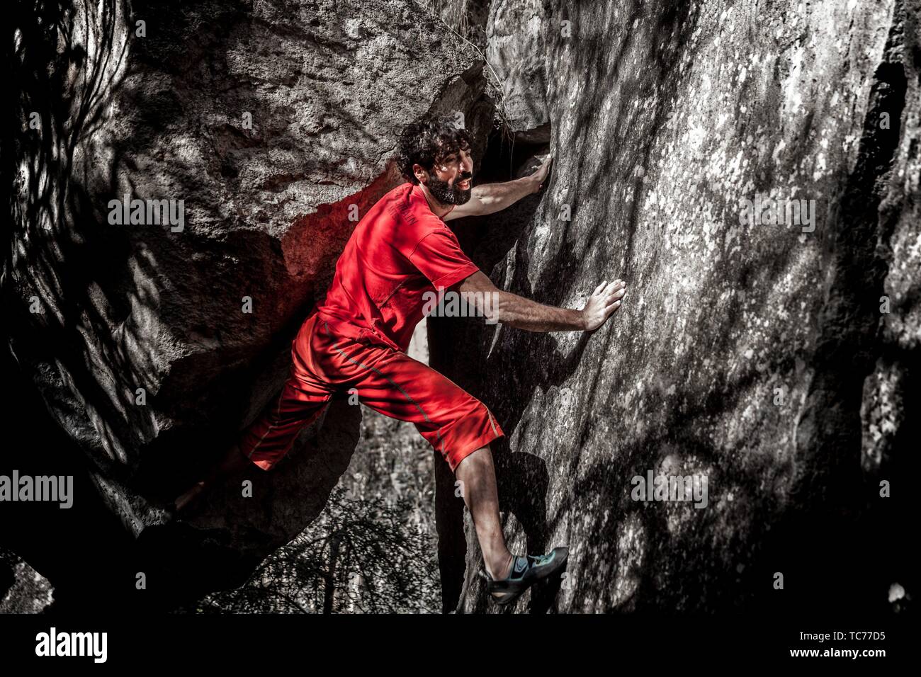 young male adult athlete doing bouldering outdoors Stock Photo